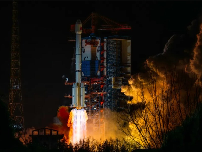 Nighttime launch of the Long March 3B rocket carrying the Shijian-25 satellite, illuminating the surroundings at Xichang Satellite Launch Center.