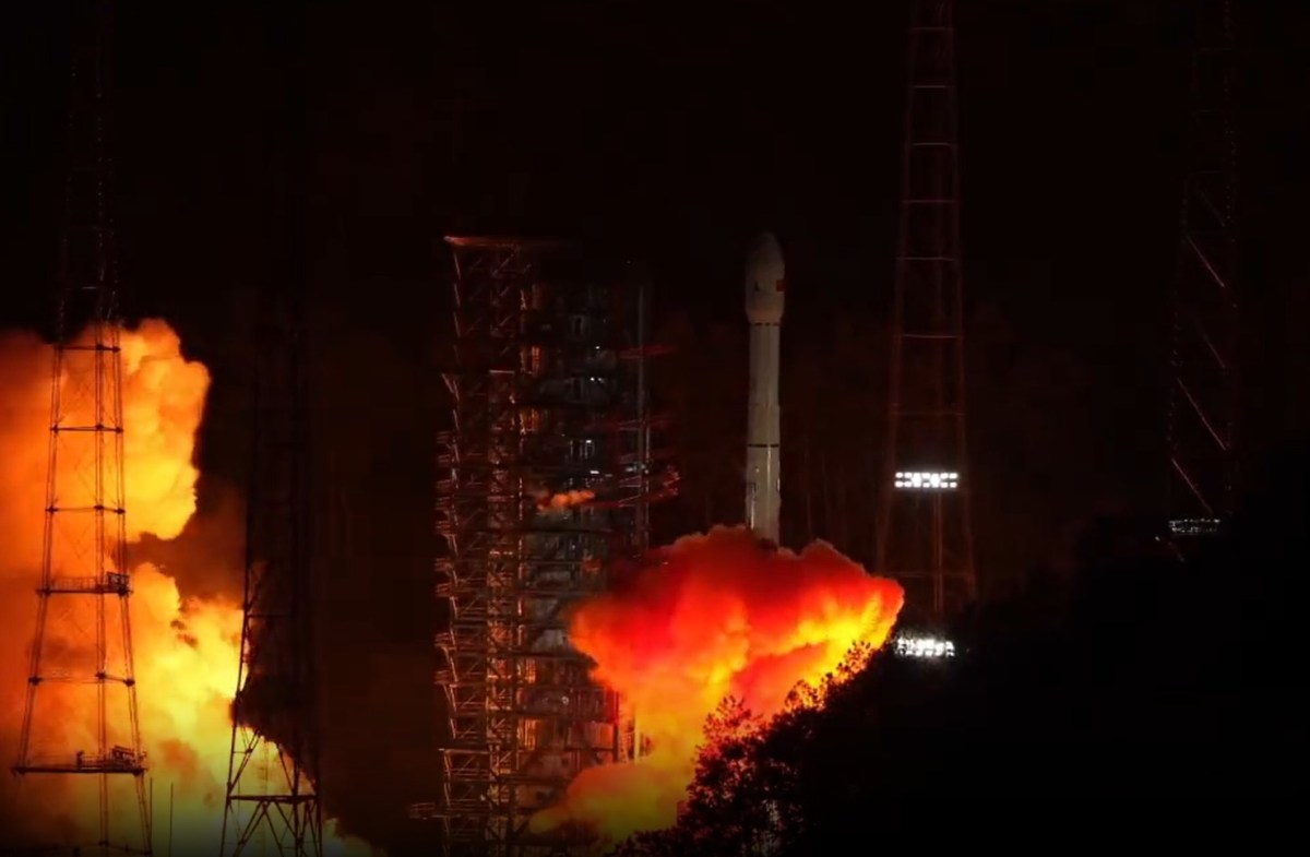 China's Long March 3B rocket launches the Tianwen-2 asteroid and comet mission from Xichang Satellite Launch Center at night, with bright orange flames and smoke illuminating the pad.